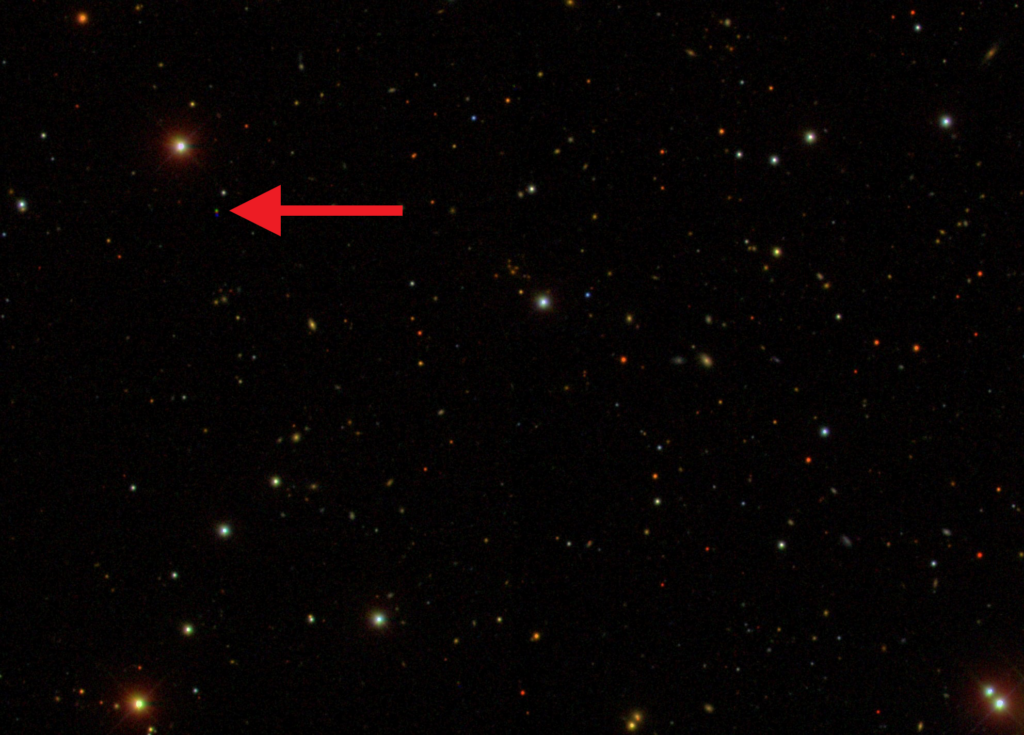 A red arrow in the top left of a star field